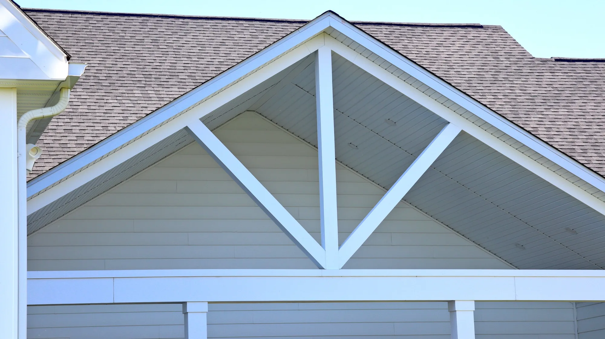 The white truss detail in the back porch gable, under a dark shingle roof